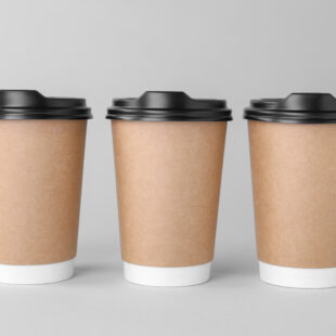 Paper cups with black lids on light grey background.