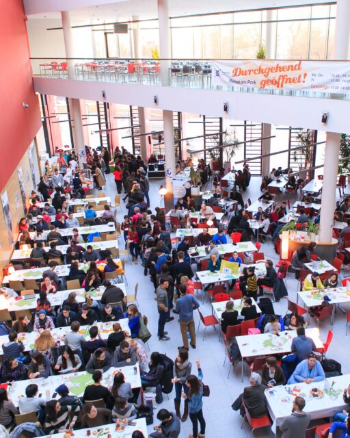 2016 🧡1: Das allererste International Café findet in der Mensa am Park statt, 350 internationale Studis kommen. 🌍2: Das SSZ ist damals noch in der Goethestraße 6 zu finden, mit stylischen roten Beratungstresen. 3: Die Mensa am Medizincampus ist noch Teil der Baustelle - es gibt Essen unten im Hof in einem Interims-Bau. 🍽️4: Das Studentenwerk wird 25 Jahre alt: Zur Feier gibt es eine Jubiläumswoche in den Mensen mit u.a. diesem Kuchenbuffet in der Mensa am Park. 5: Wir haben neue Mehrwegbecher in unseren Mensen & Cafeterien, das ist das Gewinner-Motiv einer Studentin nach einem Wettbewerb. (Heute verzichten wir der Nachhaltigkeit zuliebe natürlich auf Wegwerfbecher. ♻️)6: Beim Firmenlauf ist das StwL auch 2016 aktiv - mit nicht übersehbaren Trikots :D7: Aus der Cafeteria Beethovenstraße wird nach Umbau und Modernisierung die Cafeteria im Musikviertel mit größerem Angebot.8: Auch 2016 esst ihr gerne draußen im Sonnenschein. ☀️🌳#2016 #StudierenInLeipzig #StudentenwerkLeipzig