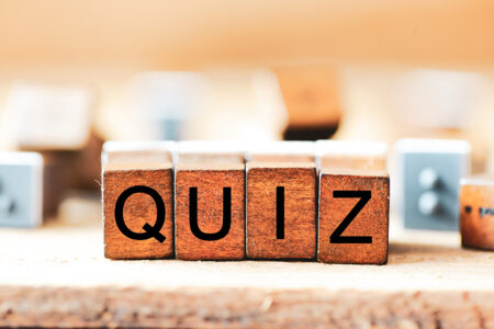 Holzwürfen auf denen Buchstaben stehen, sie bilden das Wort "Quiz"